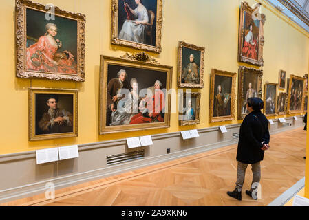 Nationalmuseum de Estocolmo, vista trasera de una mujer mirando los retratos de la nobleza del siglo XVIII en el interior del Museo Nacional de Arte, el centro de Estocolmo.