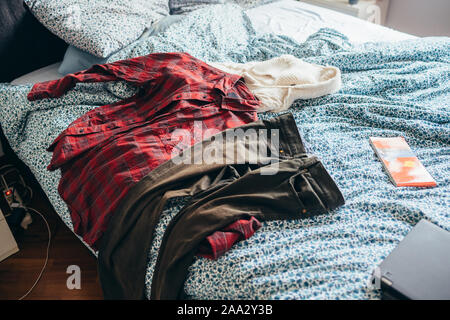 https://l450v.alamy.com/450ves/2aa2y3b/habitacion-con-dispersion-de-ropa-sucia-en-la-cama-2aa2y3b.jpg