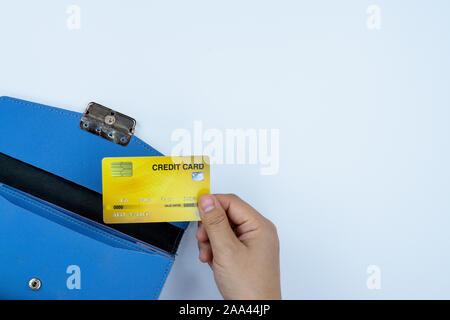 Mujer teniendo a mano la tarjeta de crédito de pago monedero azul sobre fondo blanco. Dinero y finanzas concepto, vista superior, espacio para copiar texto. Foto de stock