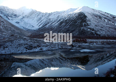 Un pequeño glaciar se refleja en las aguas de un lago de montaña en las montañas de Sichuan Daxueshan Foto de stock