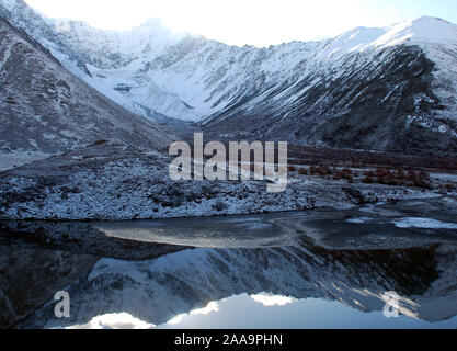 Un pequeño glaciar se refleja en las aguas de un lago de montaña en las montañas de Sichuan Daxueshan Foto de stock
