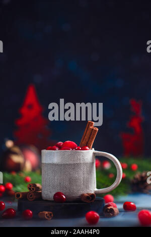 Taza de cerámica artesanal con una bebida caliente en invierno de arándano, Navidad bodegón sobre un fondo oscuro Foto de stock