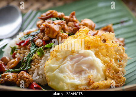 Remueva hojas de albahaca frito pollo con arroz y huevo frito. Foto de stock