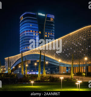 Tashkent, Uzbekistán - 30 octubre, 2019: salón de congresos y el hotel Hilton con colorida iluminación durante la noche en el Parque de la ciudad de Tashkent Foto de stock