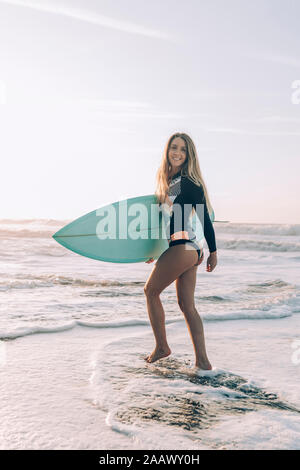 Joven rubia surfista en la playa de Sopelana, España Foto de stock