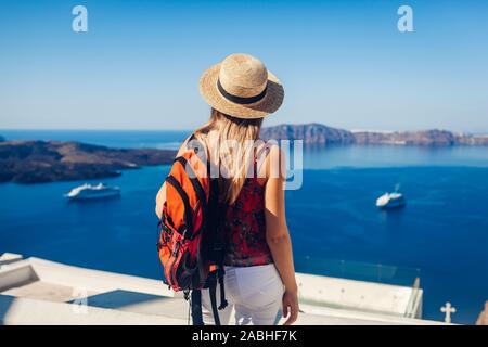 Mujer mirando viajero caldera de Fira o Thera, la isla de Santorini, Grecia. Turismo, viajes, vacaciones, concepto Foto de stock