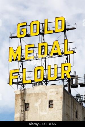 La medalla de oro amarillo neón de harina en la parte superior de elevadores de granos que son ahora parte de molino histórico museo de la ciudad en el centro de Minneapolis, Minnesota