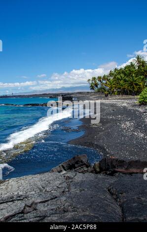 Mirando al norte a lo largo de la mayoría de la playa de arena negra de Keawaiki Bay, al norte de kona, Hawai'i, una isla de 1859 erupción del volcán Mauna Loa fluyó en esta área, w Foto de stock