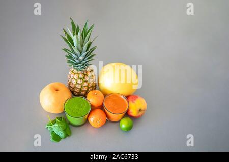 Batido de frutas tropicales y diferentes sobre fondo gris, comer sano concepto de estilo de vida Foto de stock