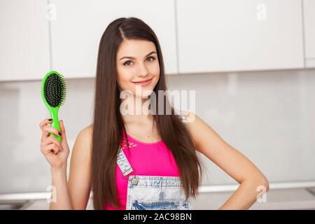 Chica posee un cepillo sin pelo y sonriendo Foto de stock