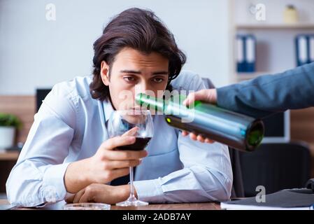 Los empleados varones de beber alcohol y de fumar cigarrillos en workpla Foto de stock