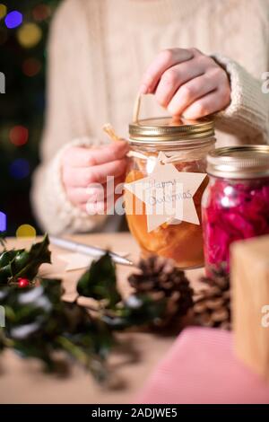 Poner etiqueta del regalo de madera reutilizables en tarros casera de conservas de fruta para regalo de Navidad ecológica Foto de stock