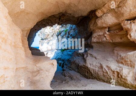 Vista lateral de la ronda de entrada al túnel singular mar cueva de roca maciza en Tropea ciudad, cerca de la famosa playa de la Rotonda. En la costa del mar Tirreno Southe