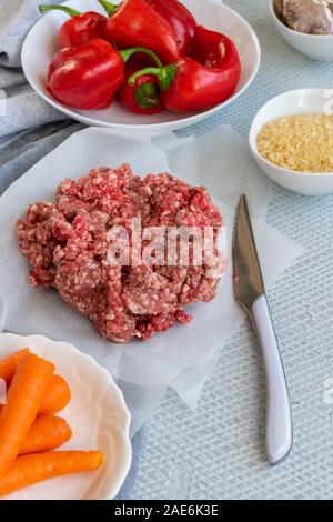 Preparación de pimientos rojos rellenos con carne picada, arroz y verduras Foto de stock