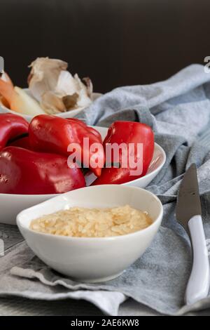 Preparación de pimientos rojos rellenos con arroz y verduras. Vegetariano vegano comer alimentos saludables. Foto de stock
