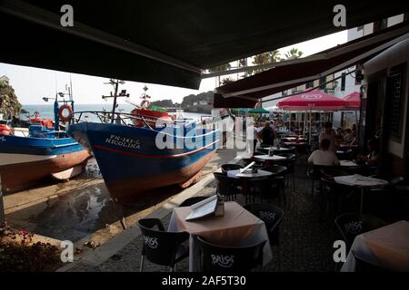Los barcos atracados en el puerto deportivo, cerca de un café en la isla de Madeira, Portugal Foto de stock