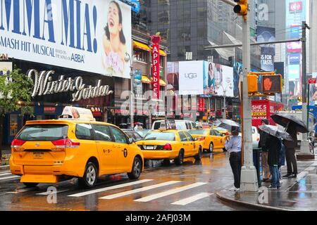 Nueva York, Estados Unidos - Junio 10, 2013: la gente visita lluvioso Broadway en Nueva York. Más de 20 millones de personas viven en el área metropolitana de Nueva York.