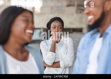 Malestar mujer negra mirando a su ex novio feliz en nuevas relaciones