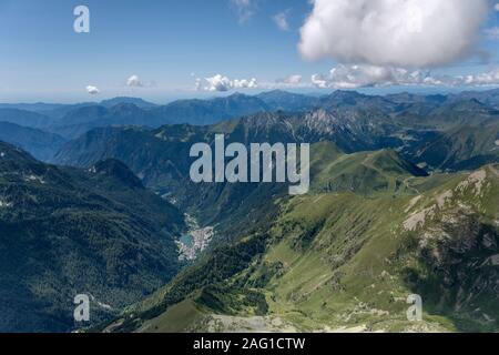 Antena, desde una avioneta, de Carona valle y aldea en las montañas Orobie, rodada en brillante luz de verano, cerca de Carona, Lombardía, Italia Foto de stock