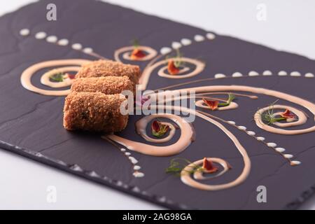 Primer plano de deliciosos dedos de pescado en un hermoso decorado pizarra negra