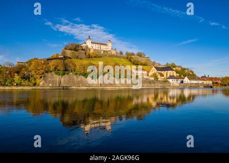 El castillo Festung Marienberg está situado en una colina sobre la ciudad, el reflejo en el río Main fluye pasado Foto de stock