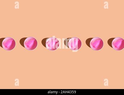 Ilustración 3D, fila de rosa taza menstrual en un cuenco de cerámica sobre fondo de color crema