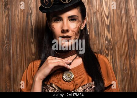 Mujer atractiva con maquillaje steampunk tocar medallón en madera  Fotografía de stock - Alamy