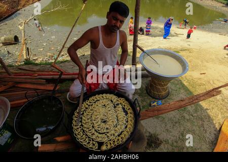 Un hombre hace dulces tradicionales en su stand en una feria Boishakhi Mela, con ocasión del Año Nuevo Bengalí. Narayanganj, Bangladesh Foto de stock
