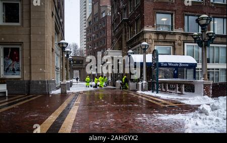 Un equipo de trabajadores vistiendo ropa de color amarillo en una tormenta de nieve Foto de stock