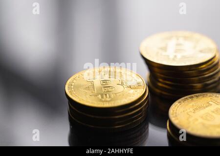 Las pilas de oro monedas en una bitcoin refleja la superficie de la mesa. Concepto cryptocurrency virtual. La minería de bitcoins negocios online. Bitcoins