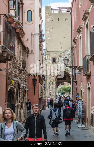 Cors Umberto street, vista con la Torre del Reloj de la Piazza 9 Aprile en Taormina comune en la zona metropolitana de la ciudad de Messina, en la costa este de Sicilia, Italia