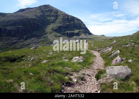 Hombre solitario caminando hacia la montaña escocés Fuar Tholl Corbett en la guarida de Coire a Bealach Mor Ruta Strathcarron, Scottish Highlands, Escocia. Foto de stock