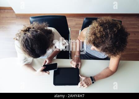 Dos mujeres empresarias trabajando juntos en la oficina. Vista desde arriba.