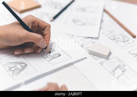 La mano de la mujer dibuja un guión gráfico para una película o una caricatura.