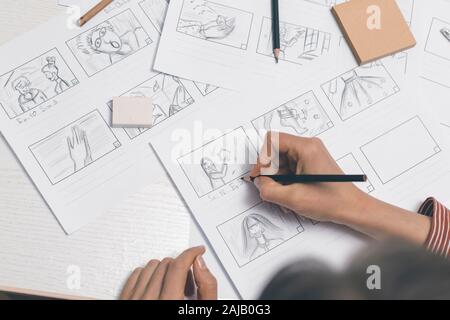 La mano de la mujer dibuja un guión gráfico para una película o una caricatura.