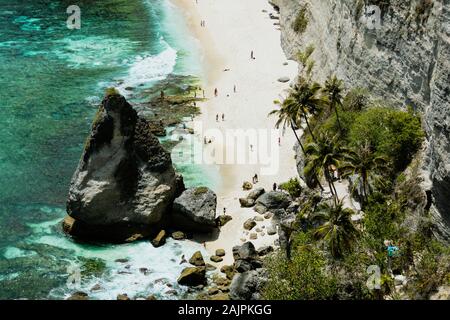 BALI, INDONESIA - Diciembre 19, 2019: el rock en el medio de la playa de arena blanca en la isla de Nusa Penida