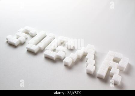 "Azúcar" escrito con pixel art letras hechas con terrones de azúcar sobre un fondo blanco. Foto de stock