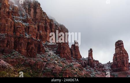 Aumento de niebla desde una colina Schnebly Formación, montañas, rocas rojas de Sedona en Arizona en una fría mañana de invierno con un cielo nublado.