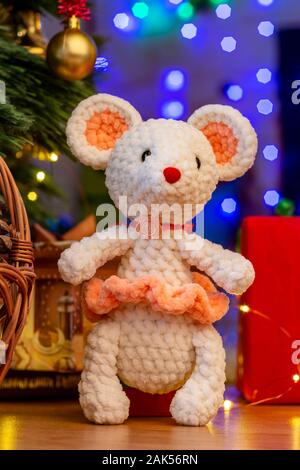Tejido blanco en un ratón de juguete sunface bajo un árbol de Navidad Foto de stock