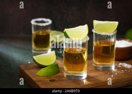 Oro mexicana Tequila shot con limón y sal en piedra oscura de fondo.