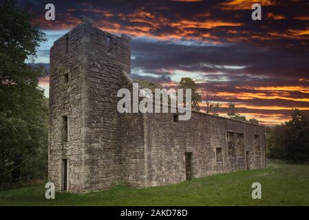 La antigua colegiata en Castle Semple en Lochwinnoch al atardecer con un espectacular cielo Firey a finales de verano.