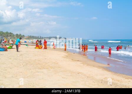 Vista panorámica de la playa de Mahabalipuram con peregrinos hindúes, Tamil Nadu, sur de la India Foto de stock