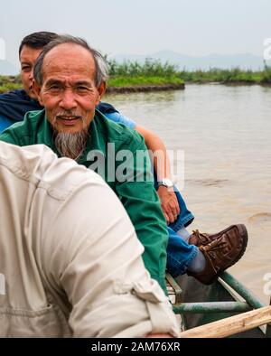Antiguo hombre asiático local con un cazo de remo en el río, Tam Coc, Ninh Binh, Vietnam, Asia