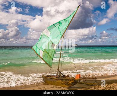 velero polinesio (Prau) en la playa de la isla de Yanaba desde Papua Nueva Guinea. En el fondo se puede ver el barco de expedición True North Foto de stock