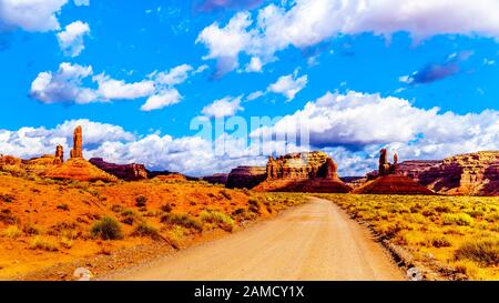 El camino de grava serpentea a través de los Buttes de arenisca roja y Pinnacles en el paisaje semi-desierto en el Valle de los Dioses, Utah, EE.UU.