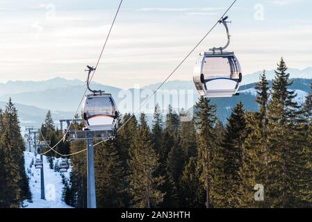 Vacíe el teleférico más boscosas laderas en un paisaje de las montañas nevadas de los Alpes en invierno Foto de stock