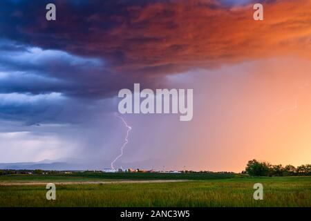 Paisaje escénico de verano y colorido cielo al atardecer con rayos de tormenta y fuertes lluvias sobre Broomfield, Colorado