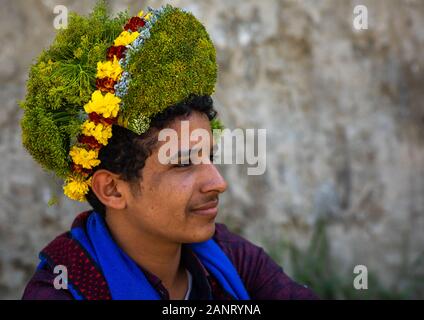 Retrato de un hombre vestido con flor de una corona de flores en la cabeza, en la provincia de Jizan Addayer, Arabia Saudita Foto de stock