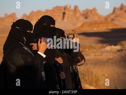 Las mujeres saudíes en negro niqabs tomando fotos, Al Madinah Provincia, Alula, Arabia Saudita Foto de stock