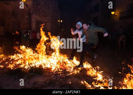 Vilanova d'Alcolea, Castellón, España - 19 de enero de 2019: Dos personas saltando juntas sobre los fuegos en el tradicional festival de San Antonio